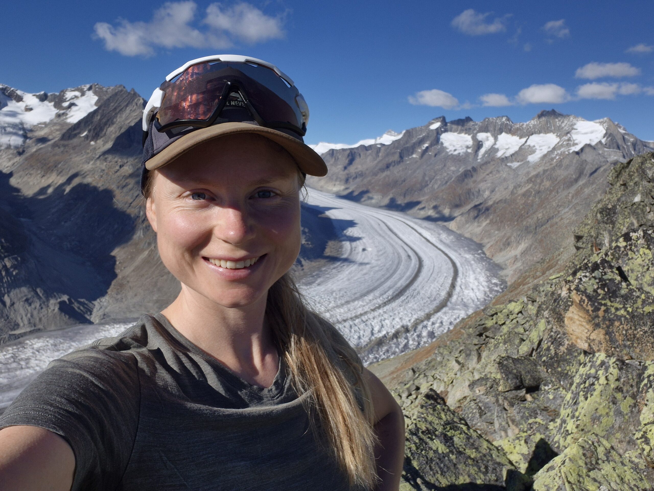 a group of trees covered in snow under a cloudy blue sky